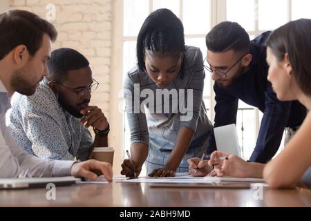 Arican amerikanischen Tausendjährigen weibliches team leader Schreiben konzentriert. Stockfoto