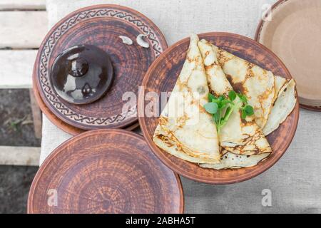 Pfannkuchen auf Keramik Servierplatte. Tabelle Einstellung in nationalen Traditionen mit französischen Crepes. Stockfoto