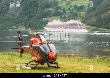 Geiranger, Geirangerfjord, Norwegen - 18. Juni 2019: Hubschrauber auf Fjord Hafen geparkt. Touristische Schiff Fähre Liner für den Hintergrund. Stockfoto