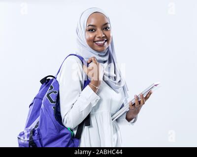 Portrait von Happy afrikanischen Moderne muslimische Studentin vor weißem Hintergrund tragen traidiional Sudan moslemischen hijab Fashion Stockfoto