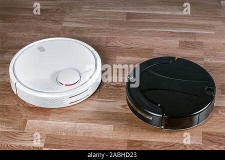 Verschiedene Roboter Staubsauger, effektive Staub absorption in Abwesenheit der Hausbewohner, moderne Smart Home Reinigung Gerät. Stockfoto