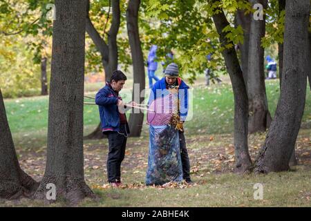 Leute sammeln Blätter in großen Plastiktüten in Tsaritsyno Park ща Gefallenen der Stadt Moskau, Russland Stockfoto