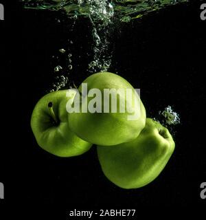Drei frische grüne Äpfel im Wasser Stockfoto