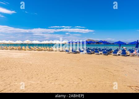 Naxos, Griechenland - 22. Mai 2017: Sonnenliegen mit Sonnenschirmen am Strand von Agios Georgios, sehr beliebten Ferienort auf der Insel Naxos, Griechenland. Stockfoto