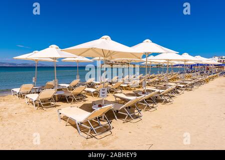 Naxos, Griechenland - 22. Mai 2017: Sonnenliegen mit Sonnenschirmen am Strand von Agios Georgios, sehr beliebten Ferienort auf der Insel Naxos Stockfoto