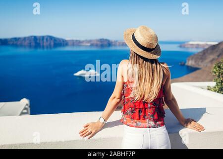 Frau Traveler in der Caldera von Fira oder Thera suchen, Santorini, Griechenland. Tourismus, Reisen, Ferienhäuser Konzept Stockfoto