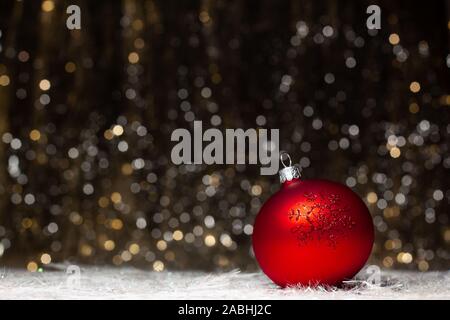 Weihnachtsschmuck Zusammensetzung der rote Abend Ball mit rotem glitter Schneeflocken auf der rechten Seite auf dunklem Hintergrund mit Silber und mit Gold. Stockfoto