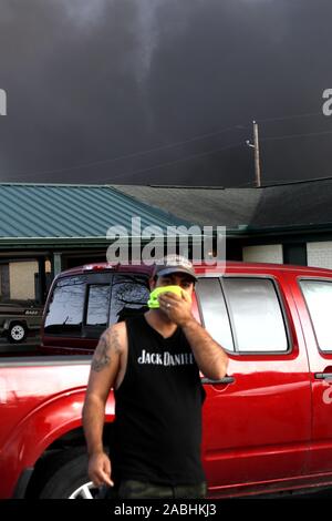 Houston, USA. 27 Nov, 2019. Ein Anwohner deckt seinen Mund mit einem Handtuch in der Nähe einer Chemiefabrik von TPC Gruppe, in der die Explosion ereignete sich in Port Neches, etwa 150 km östlich von Houston, Texas, in den Vereinigten Staaten, an November 27, 2019. Drei Menschen wurden in einem Chemiewerk Explosion im Südosten von Texas am Mittwoch Morgen verletzt. Credit: Steven Song/Xinhua/Alamy leben Nachrichten Stockfoto