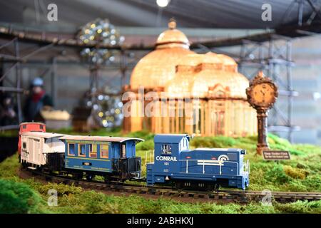 New York, USA. 26 Nov, 2019. Ein Modell der Zug fährt vorbei an der Miniatur Enid A. Haupt Wintergarten im Holiday Train Show im New York Botanical Garden in New York, USA, November 26, 2019. Der New York Botanical Garden rollt in der Ferienzeit mit Ihren jährlichen Urlaub Zug zeigen. Jetzt in ihrer 28. Ausgabe, die jährliche Veranstaltung Transporte Besucher zu einer Miniatur Metropole als Model Trains zip durch eine bezaubernde Anzeige von mehr als 175 Sehenswürdigkeiten in New York City, jedes mit Rinde neu erstellt, Lotus pods, Eicheln, Zimtstangen und anderen natürlichen Materialien. Quelle: Xinhua/Alamy Live N Stockfoto