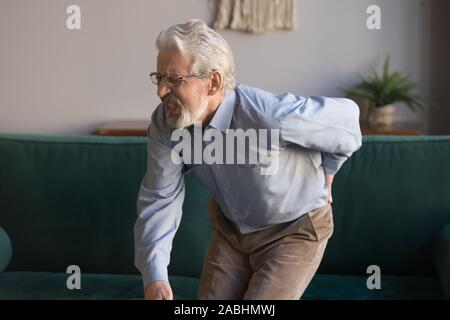 Älterer Mann windet sich in Schmerzen leidet unter geringer Belastung zurück Stockfoto