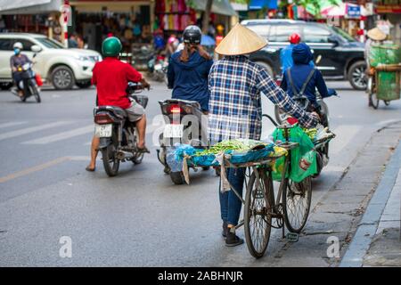 Hanoi, Vietnam - 11. Oktober 2019: ein Street Food Verkäufer nehmen Obst um auf seinem Fahrrad zu verkaufen in der Stadt Stockfoto