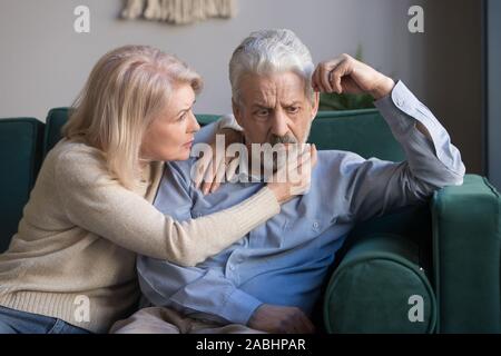 Im mittleren Alter Frau tröstend umgekippt, grauhaariger Mann Stockfoto