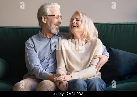 Überglücklich Lachen senior Paar, sitzen auf der Couch Stockfoto