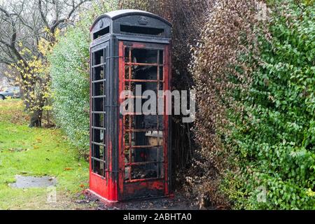 Anti- Sozialverhalten - Ausgebrannt rote Telefonzelle in der South Yorkshire Dorf Barnburgh, die wie ein Dorf Bibliothek verwendet wurde Stockfoto