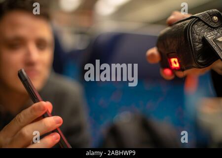 Junge sympathisch Mann zeigt ein elektronisches Ticket Dirigent auf den Zug auf Ihrem Smartphone. Prüfen über das Auslesen des Geräts Stockfoto