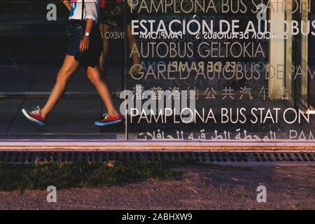 Pamplona Busbahnhof Signal in verschiedenen Sprachen mit einer Person im Hintergrund Stockfoto