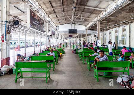 Die lokale Bevölkerung im Wartebereich Warten, Yangon Bahnhof, Yangon, Myanmar. Stockfoto