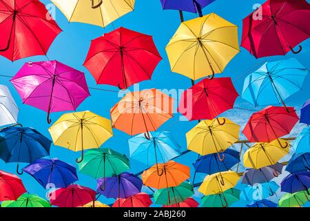 Bunte Sonnenschirme hängen in der Luft von unten gesehen Stockfoto