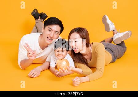 Glückliche junge Familie Holding piggy Bank Stockfoto