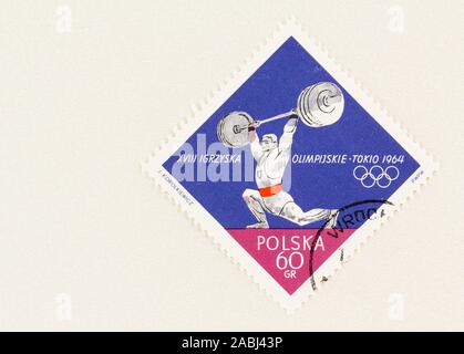 SEATTLE, Washington - Oktober 9, 2019: Gewichtheber auf Briefmarke 1964 von Polen, zum Gedenken an 18. Olympischen Sommerspiele in Tokio. Stockfoto