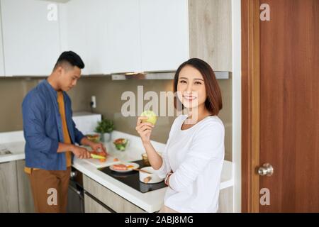 Foto von glückliches junges Paar Vorbereitung in der Küche zusammen zu essen. Familie Konzept. Stockfoto