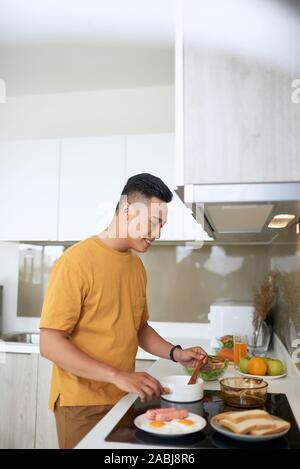 Happy asiatischer Mann Zubereitung von Speisen in der Küche zu Hause. Stockfoto