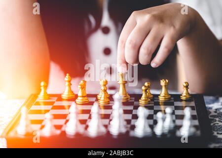 Closeup Mädchen Hand spielt Schach Brettspiel für Gehirn und Strategie Schulungskonzept. Stockfoto