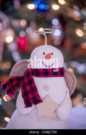 Nahaufnahme eines Engels Schnee Mann vor einen beleuchteten Weihnachtsbaum zu Hause Stockfoto