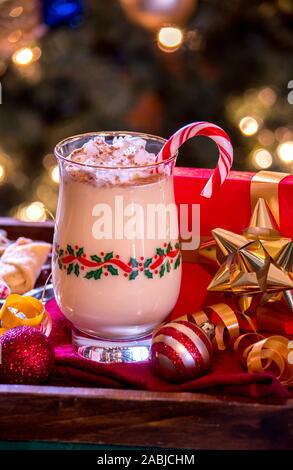 Urlaub Eierlikör mit Schlagsahne und eine Zuckerstange ist perfekt, mit einem kleinen Geschenk zu Weihnachten und festliche Dekorationen Stockfoto