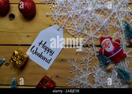 Happy Weekend schreiben, die auf dem Etikett mit Holz- Hintergrund. Rahmen der Weihnachtsdekoration. Stockfoto