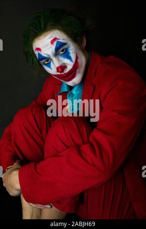 Mann verkörpert der Joker. Porträt eines Mannes im Anzug mit clown Make-up und grüne Haare. Joker cosplay. Stockfoto