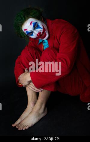 Mann verkörpert der Joker. Porträt eines Mannes im Anzug mit clown Make-up und grüne Haare. Joker cosplay. Stockfoto