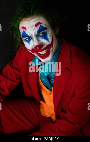 Mann verkörpert der Joker. Porträt eines Mannes im Anzug mit clown Make-up und grüne Haare. Joker cosplay. Stockfoto