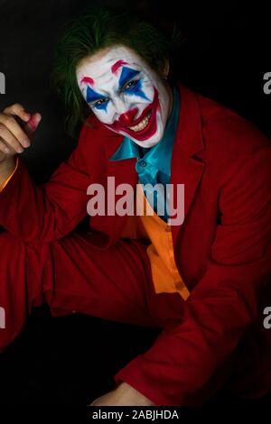 Mann verkörpert der Joker. Porträt eines Mannes im Anzug mit clown Make-up und grüne Haare. Joker cosplay. Stockfoto