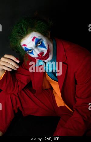 Mann verkörpert der Joker. Porträt eines Mannes im Anzug mit clown Make-up und grüne Haare. Joker cosplay. Stockfoto