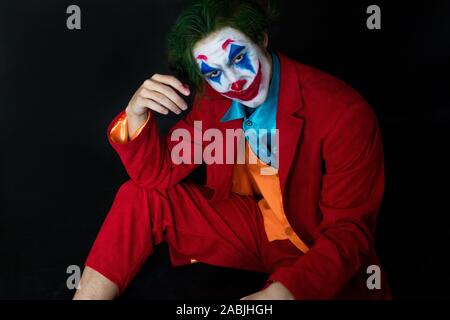 Mann verkörpert der Joker. Porträt eines Mannes im Anzug mit clown Make-up und grüne Haare. Joker cosplay. Stockfoto