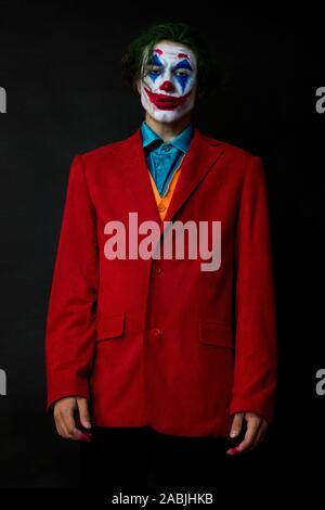 Mann verkörpert der Joker. Porträt eines Mannes im Anzug mit clown Make-up und grüne Haare. Joker cosplay. Stockfoto