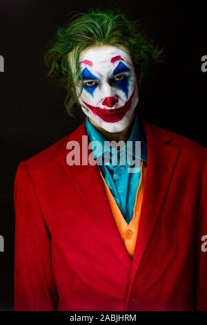 Mann verkörpert der Joker. Porträt eines Mannes im Anzug mit clown Make-up und grüne Haare. Joker cosplay. Stockfoto