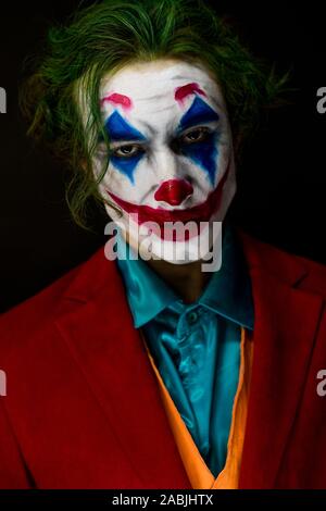 Mann verkörpert der Joker. Porträt eines Mannes im Anzug mit clown Make-up und grüne Haare. Joker cosplay. Stockfoto