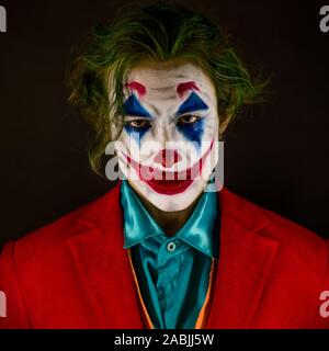 Mann verkörpert der Joker. Porträt eines Mannes im Anzug mit clown Make-up und grüne Haare. Joker cosplay. Stockfoto