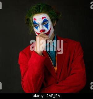 Mann verkörpert der Joker. Porträt eines Mannes im Anzug mit clown Make-up und grüne Haare. Stockfoto