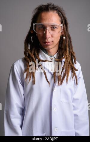 Junger Mann Arzt mit Dreadlocks tragen Schutzbrille agai Stockfoto