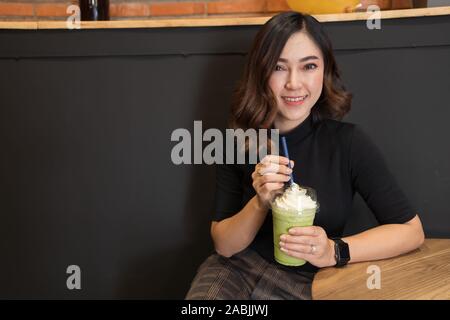 Frau trinken grünen Tee frappe in einem Cafe Stockfoto