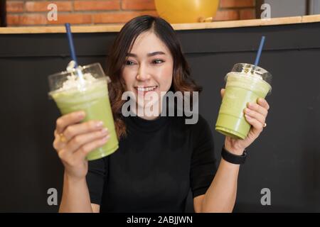 Frau trinken grünen Tee frappe in einem Cafe Stockfoto