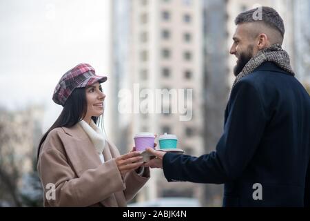 Nette junge Leute, die Tassen mit Kaffee Stockfoto