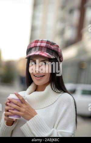 Hübsche attraktive Frau trinkt Kaffee auf der Straße Stockfoto