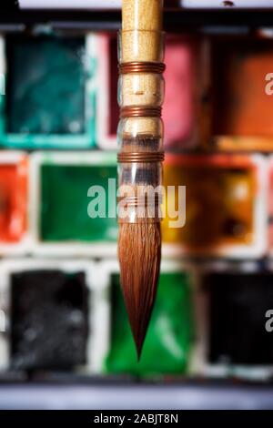 Box mit Wasserfarben und Pinsel. Stockfoto