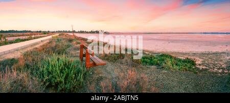 Bank am Ufer des Salt Lake von Aliki mit der Hala Sultan Tekke Moschee im Hintergrund. Dawn. Ein beliebtes Touristenziel. Larnaca, Zypern Stockfoto