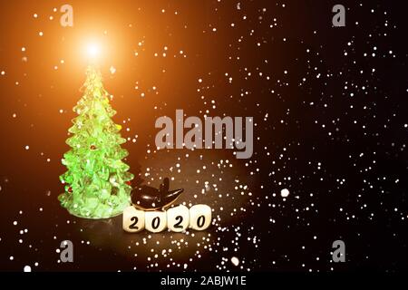 Bild einer Maus auf Würfel mit den Zahlen von 2020 sitzen, fallenden Schnee und einen Weihnachtsbaum. Weihnachten Konzept, kopieren. Stockfoto