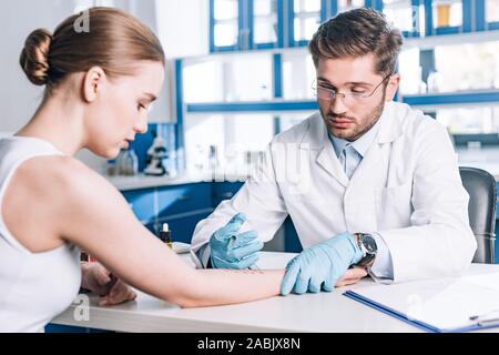 Selektiver Fokus der Allergologe halten Sie die Spritze in der Nähe der Frau in Klinik Stockfoto